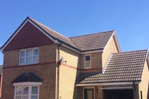 An image of a large detached house with a pitched roof, laid by AES Roofing Contractors.