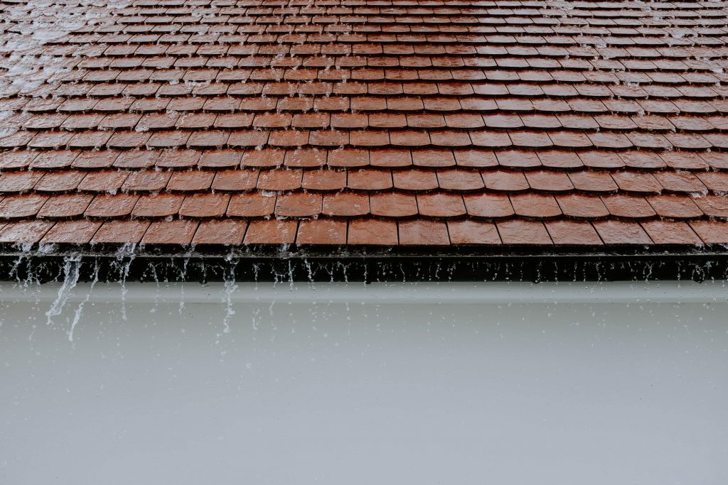 An image of the rain coming down on a pitched roof.